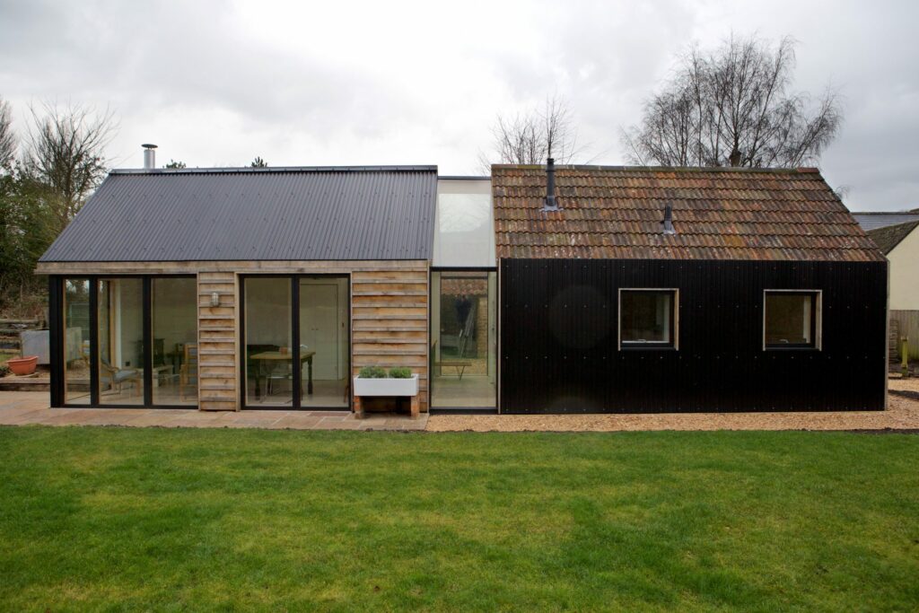 Old and new rural outbuildings connected by glass