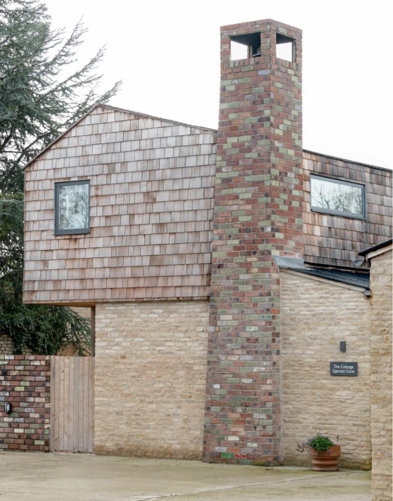 Exterior cedar shingle clad gable end with brickwork chimney