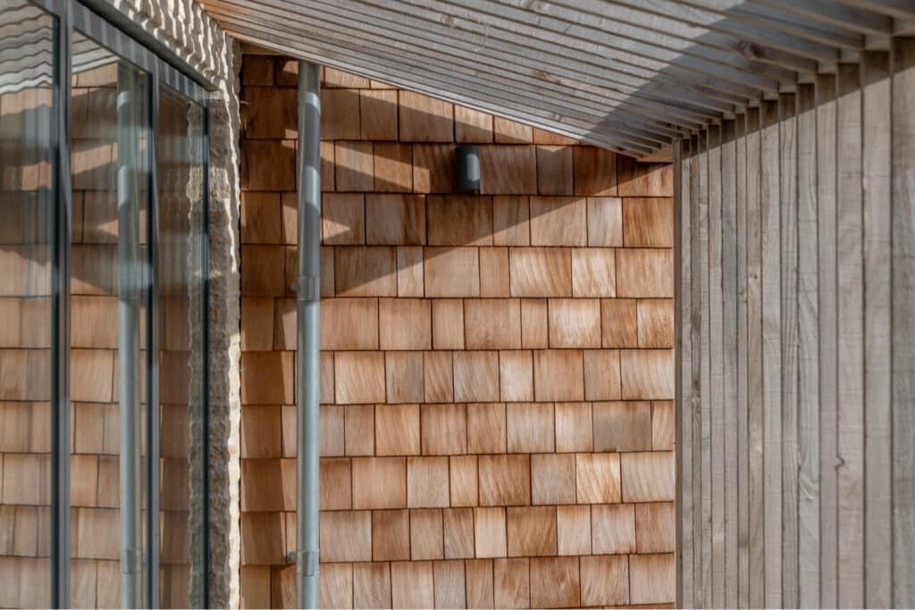 cedar shingle wall and covered external walkway new build architect house