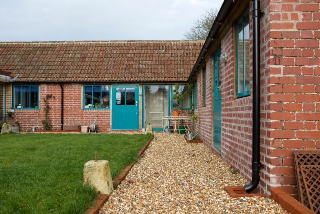 rural conversion courtyard with gravel and lawn landscaping